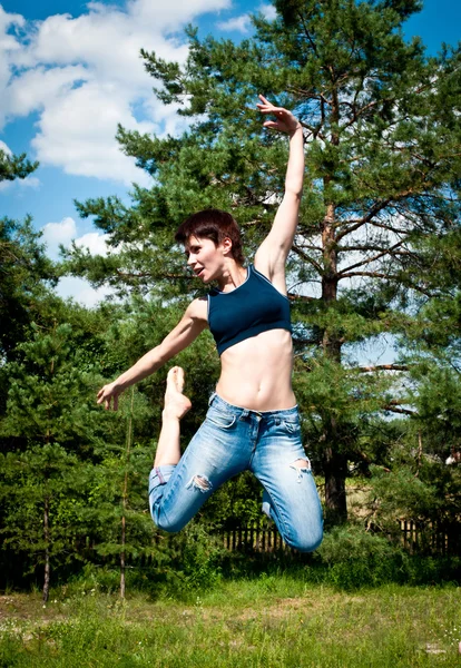 Brunett hoppar på en studsmatta — Stockfoto