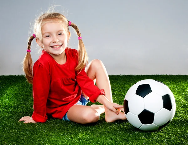 Menina com bola de futebol em botas — Fotografia de Stock