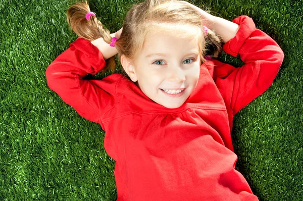 Holčička s úsměvem na trávě — Stock fotografie