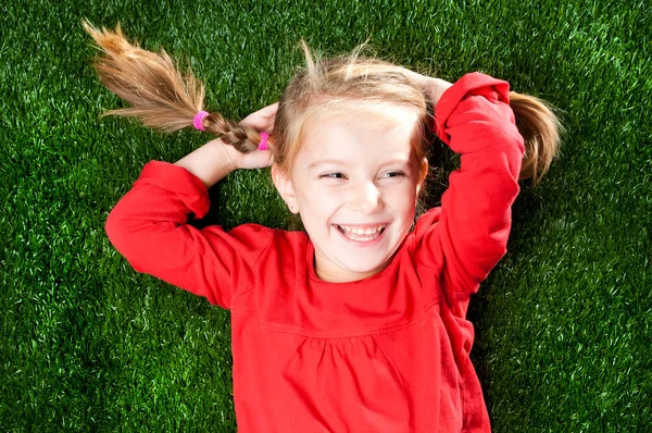 Kleines Mädchen lächelt im Gras — Stockfoto