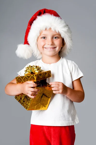 Girl with gifts in santa hat — Stock Photo, Image