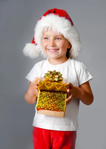 Fille avec des cadeaux dans le chapeau de Père Noël — Photo