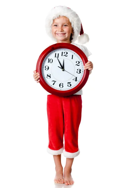 Petite fille mignonne en bonnet de Père Noël avec une horloge — Photo
