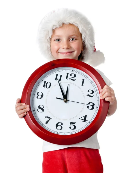 Cute little girl in santa cap with a clock Stock Picture