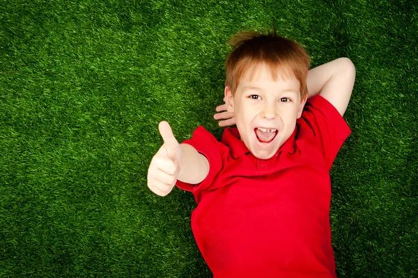 緑の芝生の上に横たわる少年 — ストック写真