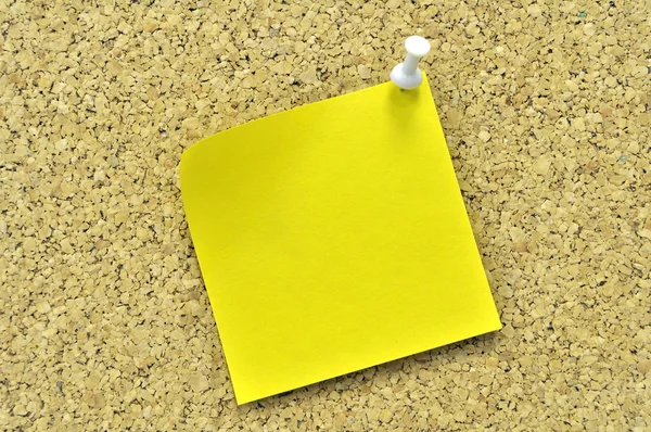 stock image Yellow sticky note on a cork board.