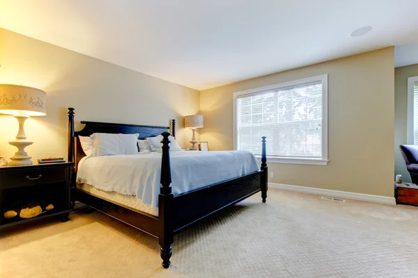 Amplio dormitorio de color beige con cama oscura. Interior . —  Fotos de Stock
