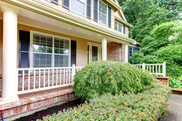 Gran casa beige con porche delantero cubierto —  Fotos de Stock