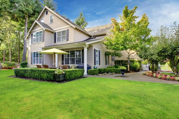Grote beige huis met groen gras Stockfoto
