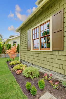 Newly renovated green house with orange wondows clipart