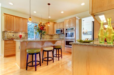 Large luxury maple wood kitchen with island and stools clipart