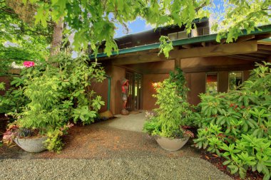 Front door of the cider house with shrubs in the front clipart