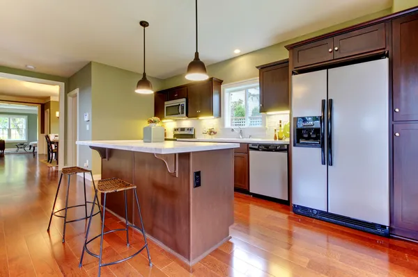 Moderne nieuwe bruin keuken met cherry vloer. — Stockfoto