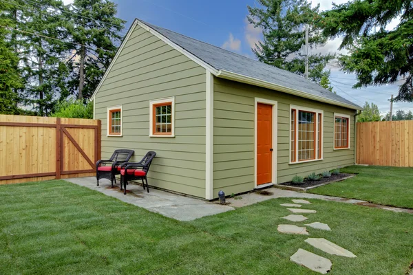 Pequena casa de hóspedes verde e laranja no quintal — Fotografia de Stock