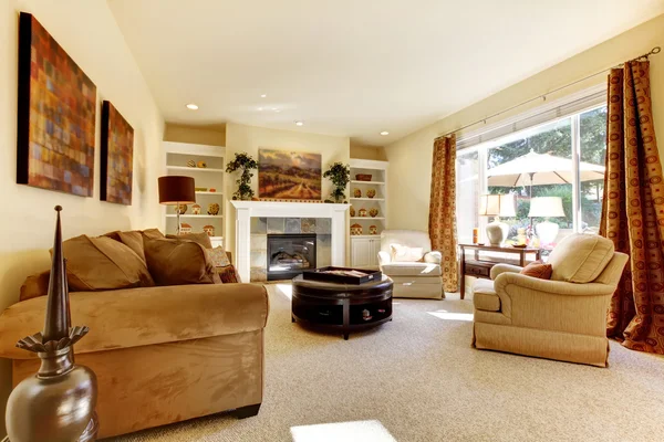 Sala de estar com arte, grande janela, sofás e lareira . — Fotografia de Stock