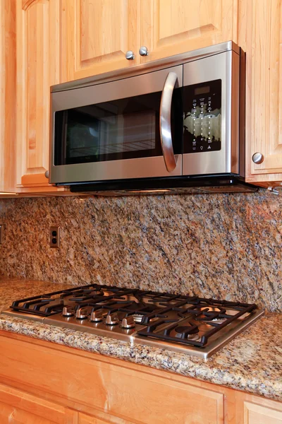 Microwave dapur dan kompor atas dengan latar belakang granit — Stok Foto