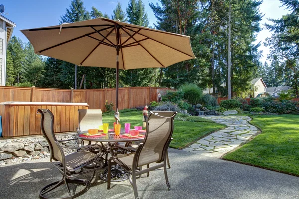 Quintal com mesa e unbrella — Fotografia de Stock