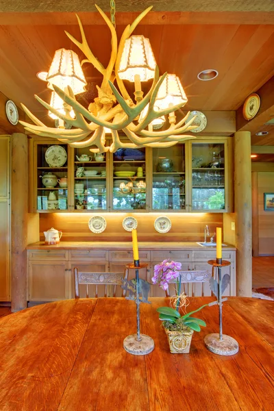 Table de salle à manger avec lumière wapiti au-dessus . — Photo