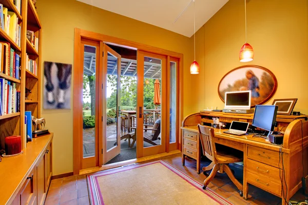 Желтый домашний офис с открытой дверью на палубу — стоковое фото