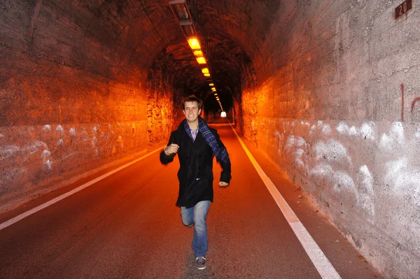 Молодий чоловік біжить всередину тунелю . — стокове фото