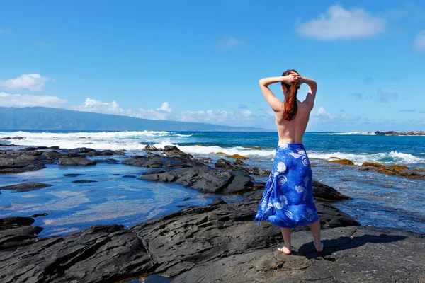 Giovani donne sta guardando l'oceano sulle rocce laviche . — Foto Stock