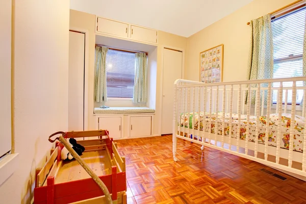 De kamer van de baby met crip en venster zetel — Stockfoto