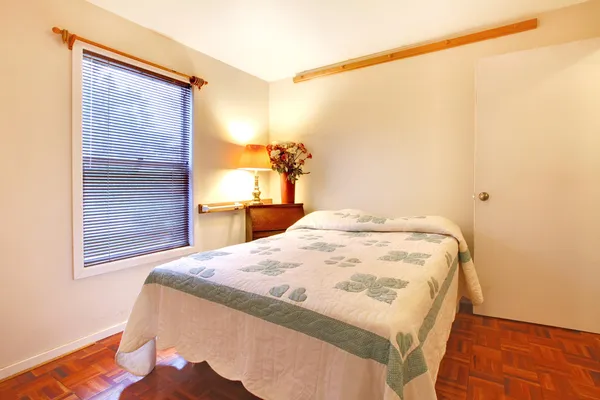 Спальня з білими стінами і вишневою дерев'яною підлогою — стокове фото