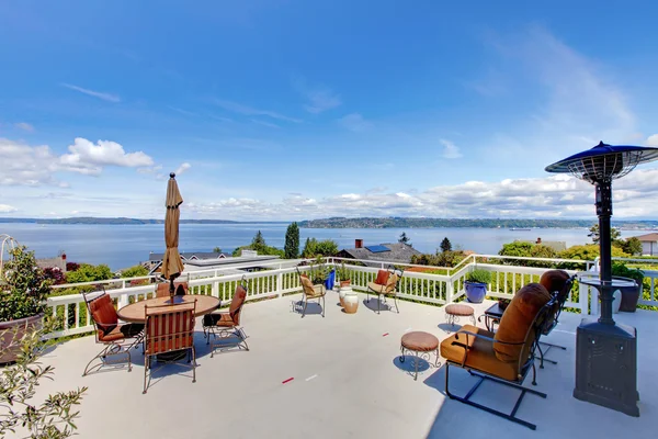 Grande terrasse de maison avec vue sur l'eau et meubles . — Photo