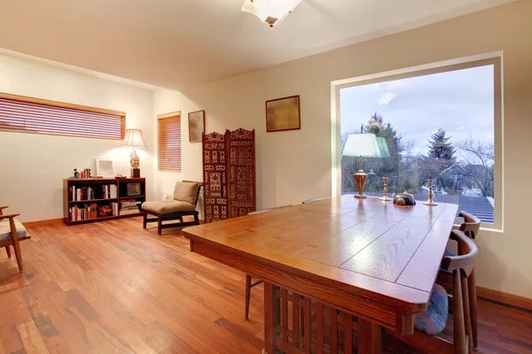 Кімната з великим дерев'яним столом і зоною читання — стокове фото