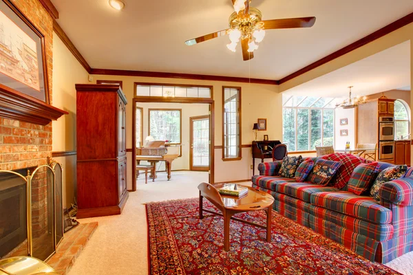 Engelsk stil vardagsrum med öppen spis och röda och blå soffa. — Stockfoto