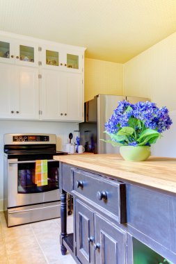 Kitchen with black island and white cabinets. clipart