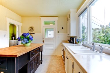 Old antique white kitchen with black island and sink. clipart