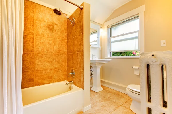 Newly remodeled bathroom with window and gold tiles. — Stock Photo, Image