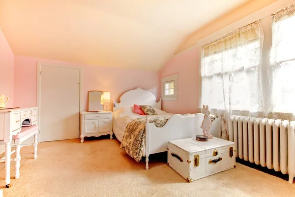 Розовая спальня с белой кроватью и тумбочкой — стоковое фото