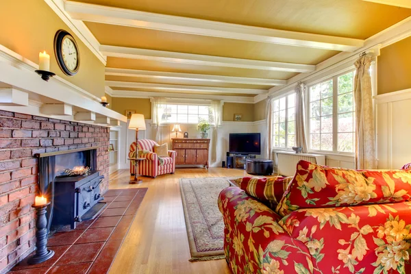 Sala de estar dourada e branca com lareira com sofá vermelho . — Fotografia de Stock