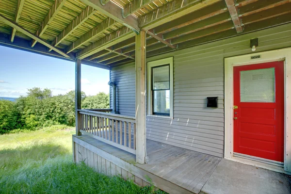 Small covered porch with red door. — Stock Photo, Image