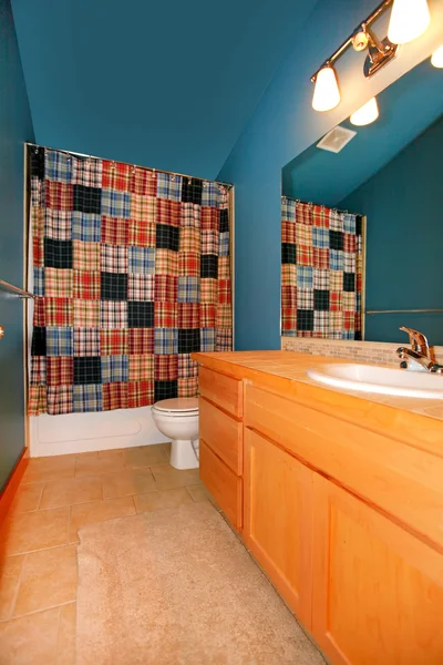 Salle de bain bleu foncé avec armoire en bois et lavabo . — Photo