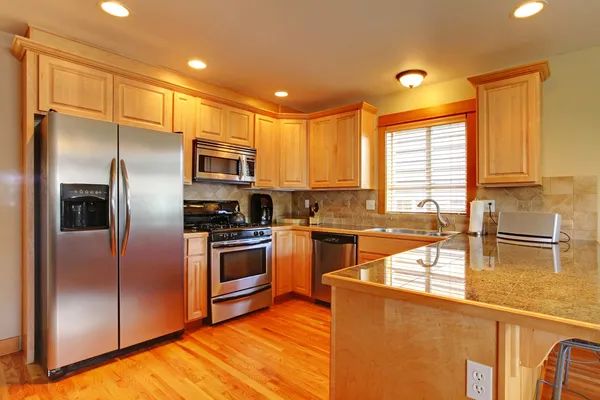 Gabinetes de arce dorado kitchenw con electrodomésticos nuevos . — Foto de Stock
