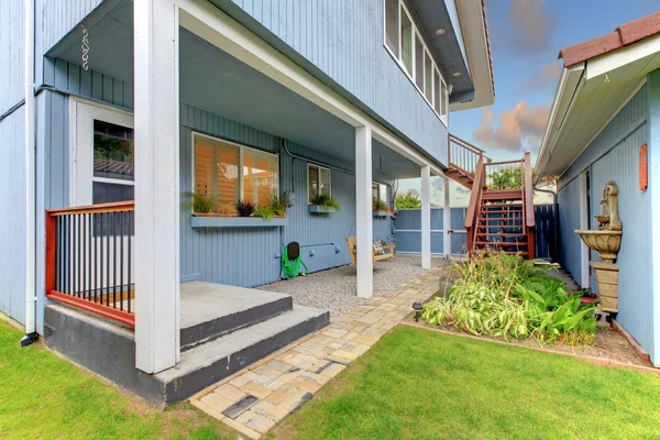 Binnenplaats omheind met blauwe huis en garage. — Stockfoto