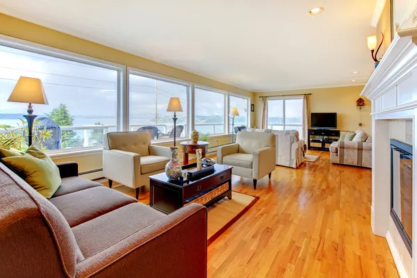 Grote luxe woonkamer met veel ramen en open haard. — Stockfoto
