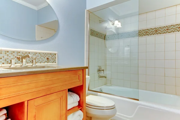 Blauwe badkamer met witte towels handdoeken en bad met glas. — Stockfoto