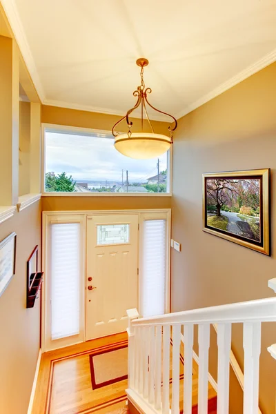 De ingang van hal met witte balustrades en deur en beige muren — Stockfoto