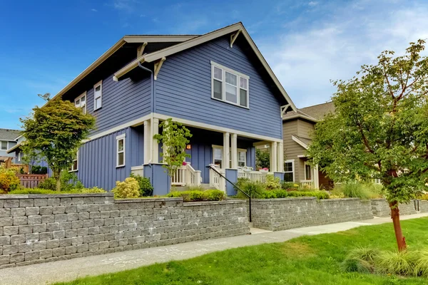 Casa azul con pared de piedra y porche cubierto . — Foto de Stock