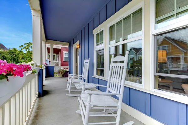 Blaues Haus mit Steinmauer und überdachter Veranda. — Stockfoto