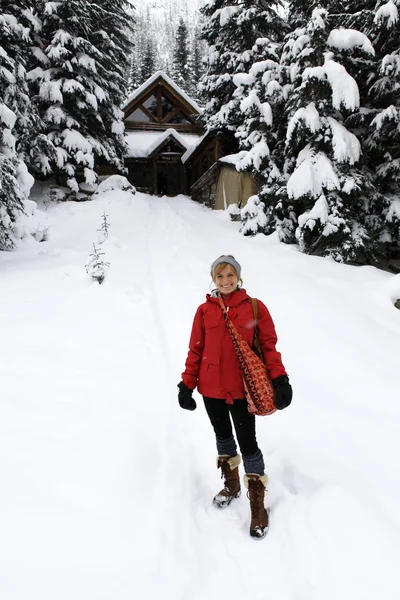 Blondýnka v lese sněhu v růžové sako. — Stock fotografie