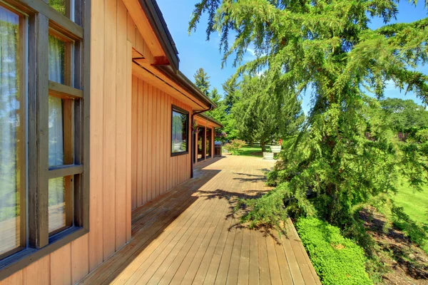 Fazenda casa de madeira com varanda e grama verde . — Fotografia de Stock
