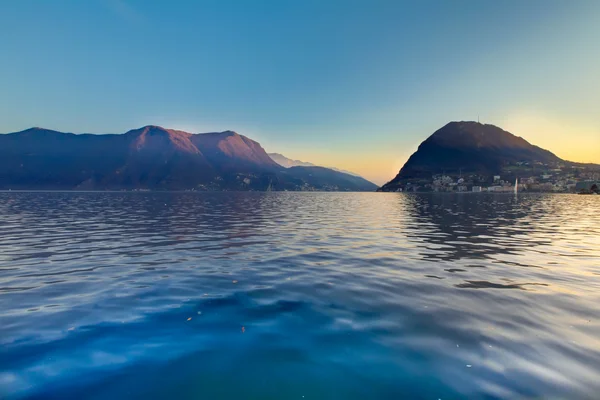 Озеро Лугано. В Швейцарии. Добрый вечер. Лодки и горы недалеко от центра города . — стоковое фото