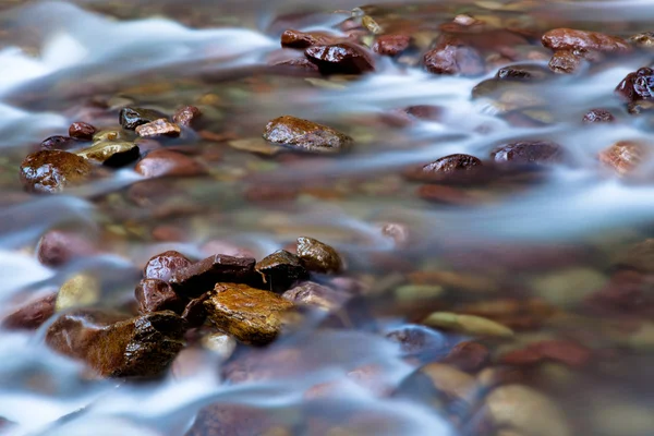 Silky water over rocks — Stock Photo, Image
