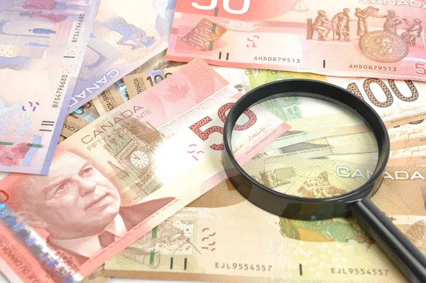 Magnifying glass on money background — Stock Photo, Image