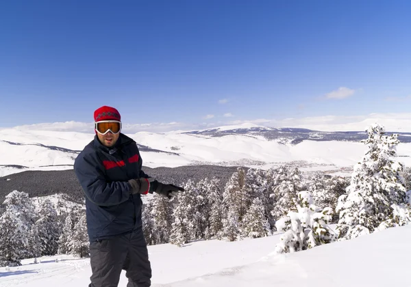 Веселый лыжник на вершине горы — стоковое фото
